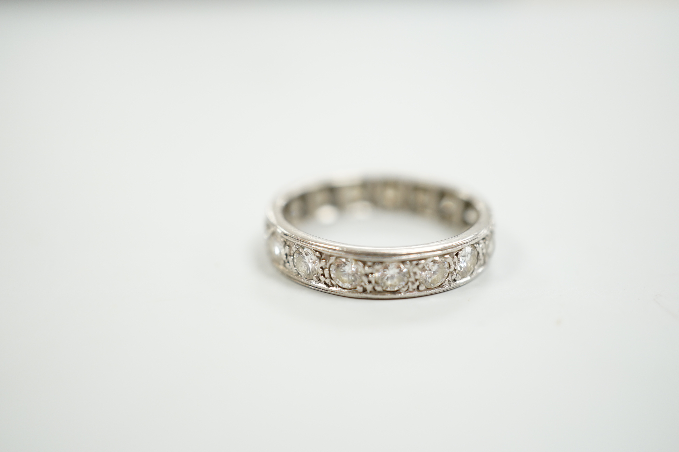 A white metal and diamond set full eternity ring, size M, gross weight 3.9 grams.